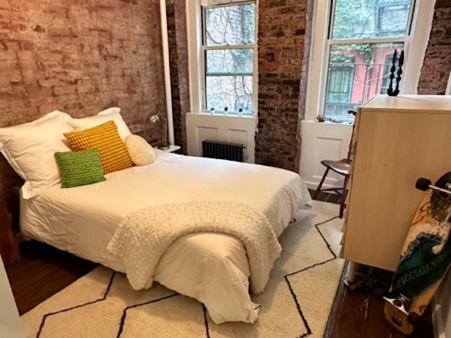 Tidy bedroom with exposed brick walls